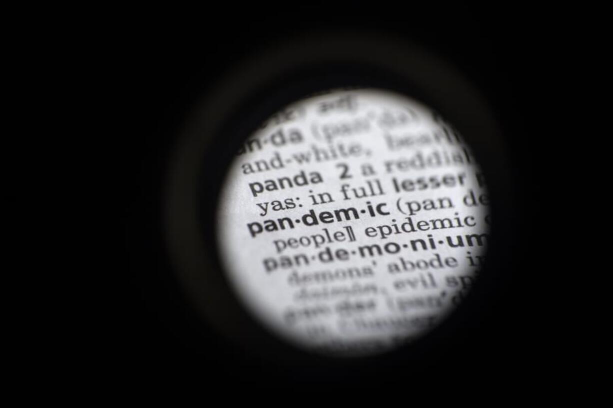 In this Saturday, Nov. 21, 2020, photo taken through a camera lens the word &quot;pandemic&quot; in seen in a dictionary in Washington. Dictionary.com declared &quot;pandemic&quot; its 2020 word of the year.