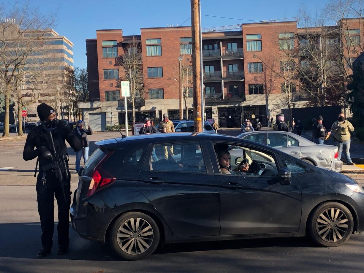 An armed protester stands on Franklin Street in downtown Vancouver on Sunday after a demonstration calling for arrests in the police shooting of Kevin Peterson Jr.