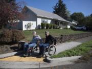 Vancouver resident Chuck Frayer, left, and friend John Williams show how they use a modern curb cut designed to make sidewalks accessible to people with all kinds of disabilities.