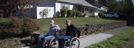 Vancouver resident Chuck Frayer, left, and friend John Williams show how they use a modern curb cut designed to make sidewalks accessible to people with all kinds of disabilities.