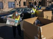 Volunteer Vicki Fitzsimmons, left, loads donations during a Drive &amp; Drop food drive event in Salmon Creek. The annual Walk &amp; Knock event was reorganized as a drive-thru due to the COVID-19 pandemic.