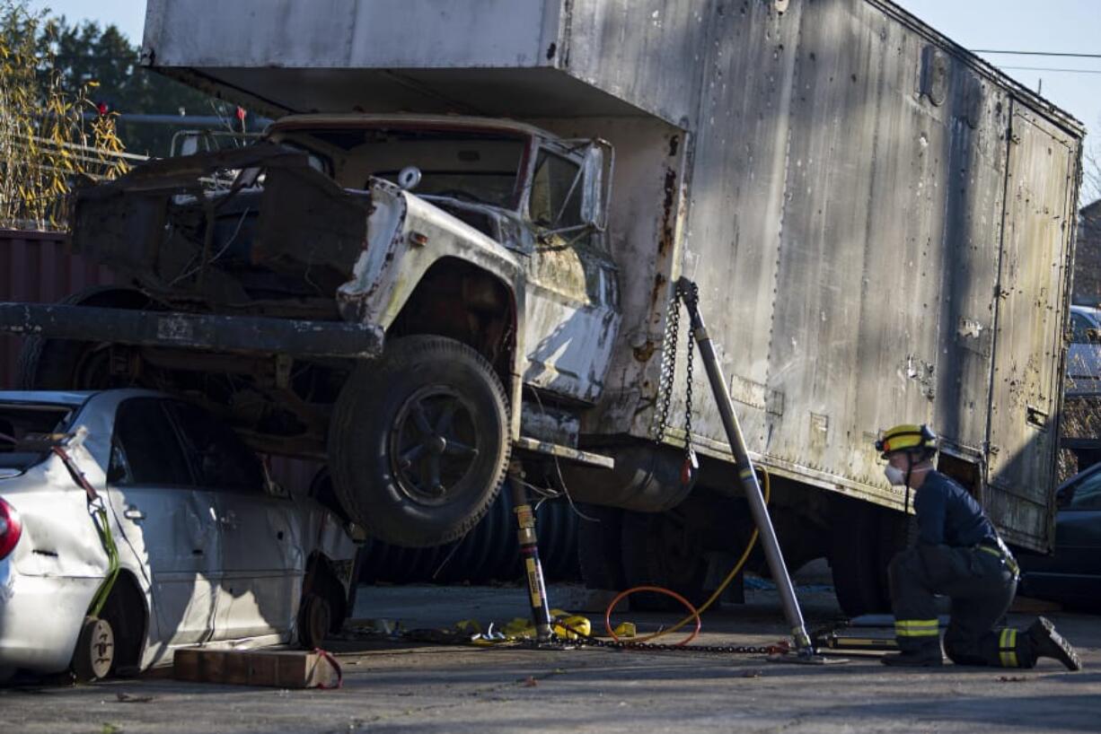 Firefighter Cory Anderson, right, joins colleagues during a simulated accident using their new heavy extrication equipment, which is capable of stabilizing up to 20,000 pounds and actively lifting 10 tons, at Vancouver Fire Department headquarters.