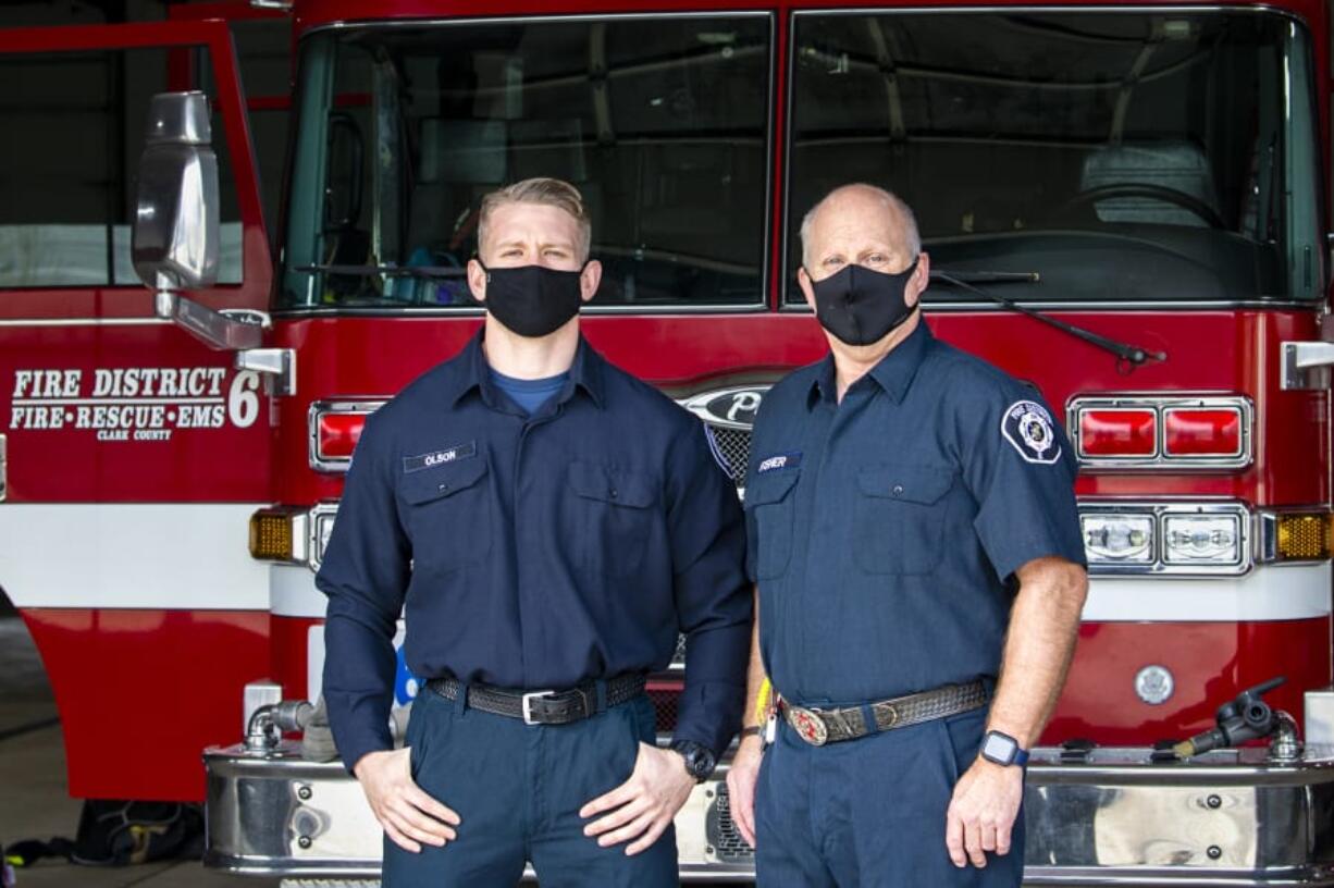 Firefighter and paramedic Max Olson, left, and firefighter and emergency medical technician Dave Fisher pose in front of a fire truck on Dec. 8 at Clark County Fire District 6 Station 61. They responded to the first reported COVID-19 case in the county.