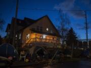 People in need enjoy a meal from Free Hot Soup Vancouver as the porch light of Share House is illuminated in downtown Vancouver.