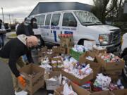 Walt Royle of Vancouver Heights United Methodist Church, left, joins fellow volunteers as they drop off Christmas gifts and supplies for workers Dec. 9 at sea at the Port of Vancouver administration building.