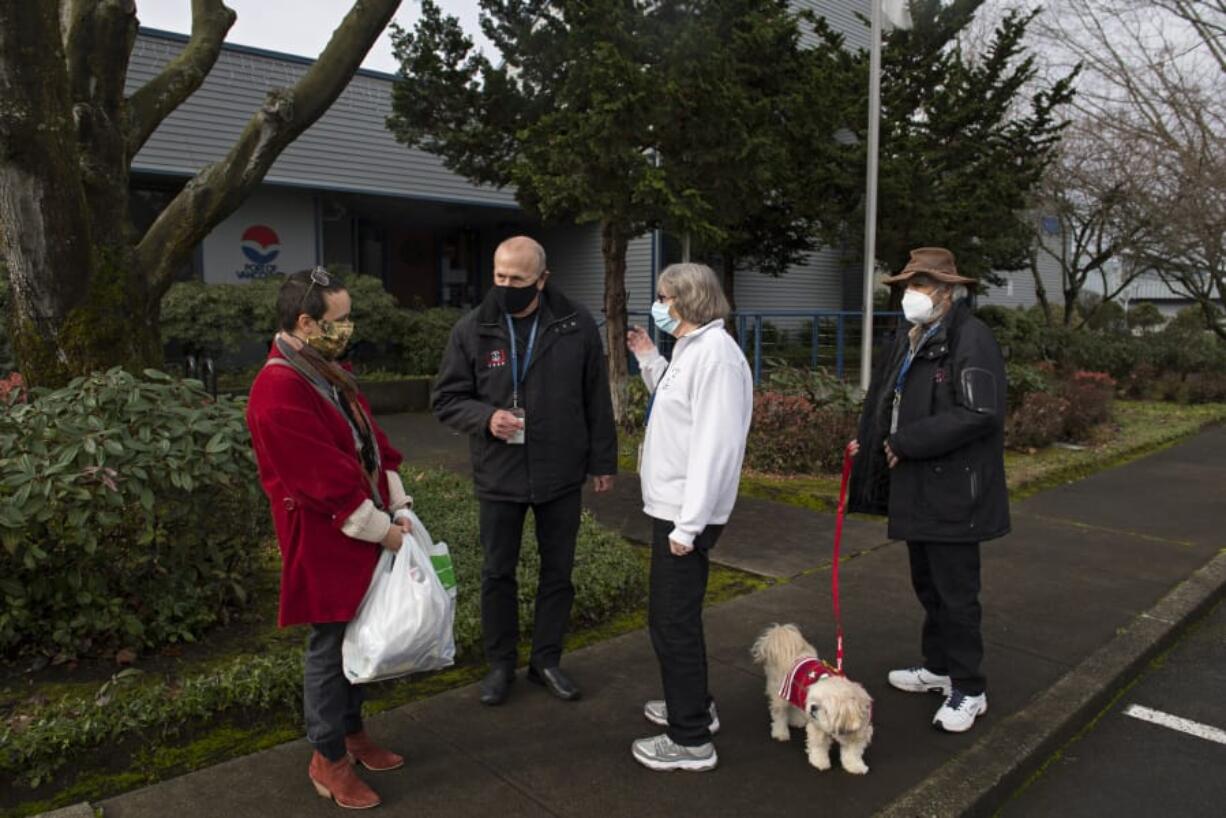 Siena Hertafeld of Vancouver United Methodist Church, from left, chats with Kent Williams, Mary Moreno and her husband, Tony, of the Seafarers Center at the Port of Vancouver administration building Dec. 9, awaiting the arrival of donations from the Vancouver Heights United Methodist Church.