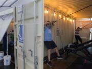 Zach Singleton, left, and Lucas Fabianek, both 16 and from Vancouver, get in a workout at Utmost Gym while using an oversize container for shelter outside Columbia Youth Center. Utmost Gym is just one part of The Columbia Future Forge, a nonprofit mentoring and training program to help young adults gain job skills and life skills.