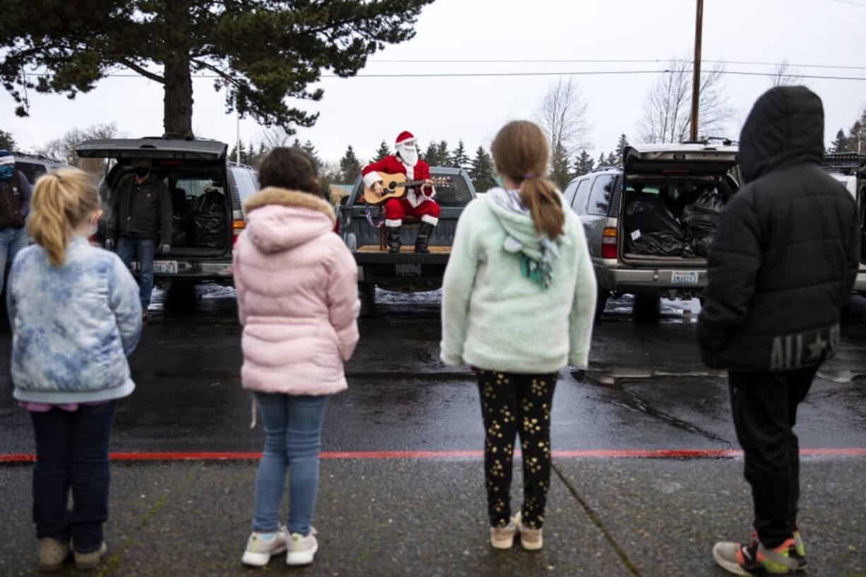 Learning Avenues students line up in front of Santa to sing Christmas carols with him for The Kids&#039; Christmas, sponsored by workers at the Bonneville Power Administration. A pandemic-riddled 2020 made the event a socially distanced one this year.