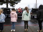 Learning Avenues students line up in front of Santa to sing Christmas carols with him for The Kids&#039; Christmas, sponsored by workers at the Bonneville Power Administration. A pandemic-riddled 2020 made the event a socially distanced one this year.