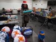 Karen Morrison of Odyssey World International Education Services sorts through gifts for children in need at Bridgeview Resource Center in Vancouver.