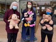 SALMON CREEK: Shirley Gross, left, and Dana Hughes, center, of Legacy Salmon Creek, and Susanne Holmberg, of Rotary Club of Three Creeks, unload new stuffed animals for children at Legacy Salmon Creek Medical Center.