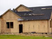 Crews work on the roof of a newly constructed house in Felida Overlook, a Ginn Group housing development.  Clark County is experiencing a surge in demand for new housing, particularly single-family housing, as the market rebounds from an initial slow period during the early months of the COVID-19 pandemic.