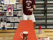 WASHOUGAL: Canyon Creek Middle School Principal Brian Amundson takes aim in the marshmallow toss challenge. Amundson and David Cooke, from Jemtegaard Middle School, battled against each other in a series of holiday-themed &quot;Minute to Win It&quot;-style competitions on Dec.