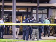 Police officers and officials congregate outside the building where a shooting reportedly happened on Tuesday, December 22, at the 505 building at the PeaceHealth Southwest Medical Center.