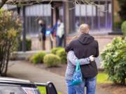 Two people embrace outside of the building where a shooting reportedly happened on Tuesday, December 22, at the 505 building at the PeaceHealth Southwest Medical Center.