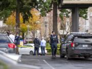 A police officer talks on his cell phone while officials congregate in front of a building where a shooting reportedly occurred on Tuesday, December 22, at the 505 building at the PeaceHealth Southwest Medical Center.