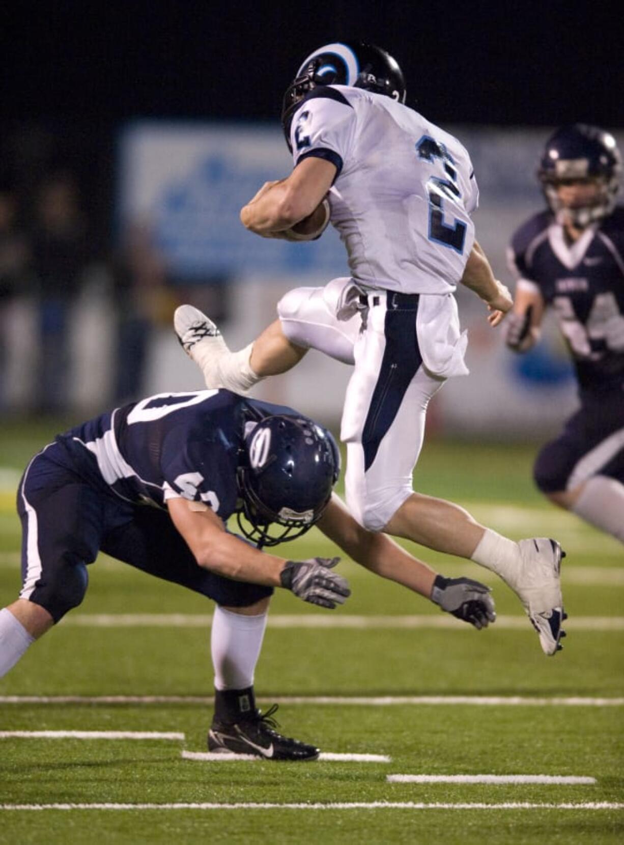 Rogers Rams QB Tyler Van Sligtenhorst, #2, leaps over Skyview LB Jason Leineweber, #40, at Kiggins Bowl, Saturday, November 15, 2008.