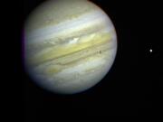 Jupiter, its Great Red Spot and three of its four largest satellites are visible in this photo taken on February 5, 1979, by Voyager 1.