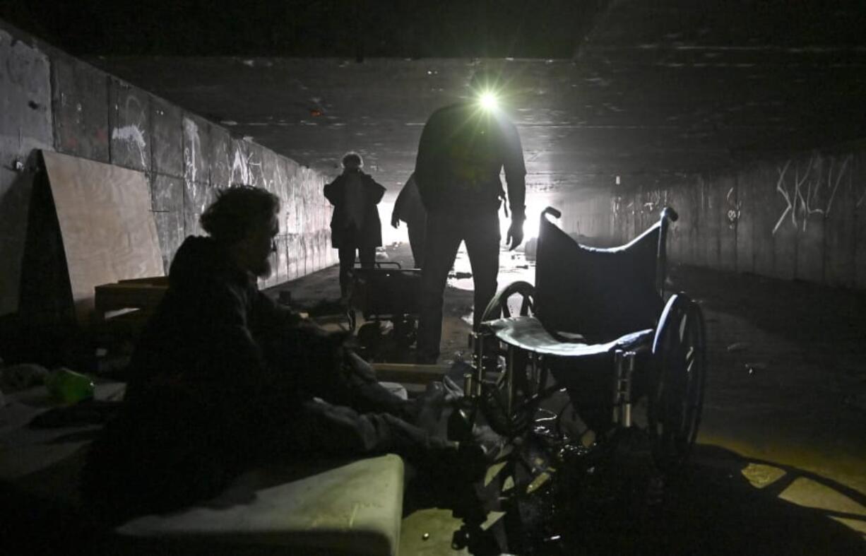 FILE - In this Dec. 5, 2020, file photo, a man who identified himself as Wheeler, left, speaks with Dave Marlon of CrossRoads of Southern Nevada, during an outreach in the underground tunnels to offer counseling, food and water to the homeless living beneath the city in Las Vegas. When census takers tried to count the nation&#039;s homeless population, they ran into many problems that could threaten the accuracy of the effort. That&#039;s what a half dozen census takers around the U.S. tell The Associated Press.