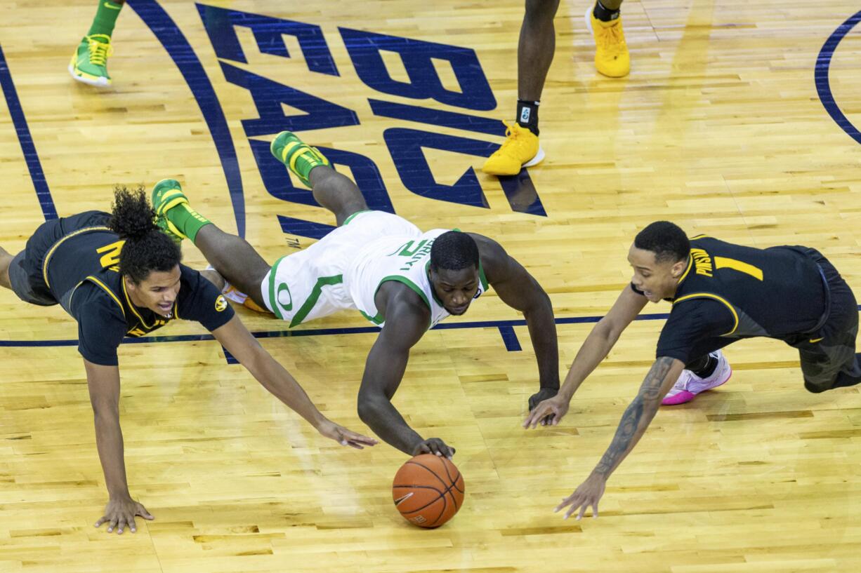 Missouri guard Dru Smith (12), Oregon forward Eugene Omoruyi (2), and Missouri guard Xavier Pinson (1) go after a loose ball during the first half of an NCAA college basketball game, Wednesday, Dec. 2, 2020 in Omaha, Neb.