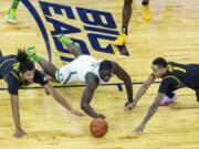 Missouri guard Dru Smith (12), Oregon forward Eugene Omoruyi (2), and Missouri guard Xavier Pinson (1) go after a loose ball during the first half of an NCAA college basketball game, Wednesday, Dec. 2, 2020 in Omaha, Neb.