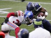 Seattle Seahawks running back Chris Carson (32) is stopped by New York Giants cornerback Darnay Holmes (30) during the second half of an NFL football game, Sunday, Dec. 6, 2020, in Seattle.