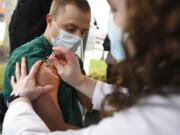 Colleen Teevan, System Pharmacy Clinical Manager at Hartford HealthCare, administers the Pfizer-BioNTech vaccine for COVID-19 to healthcare worker Connor Paleski outside of Hartford Hospital, Monday, Dec. 14, 2020, in Hartford, Conn.