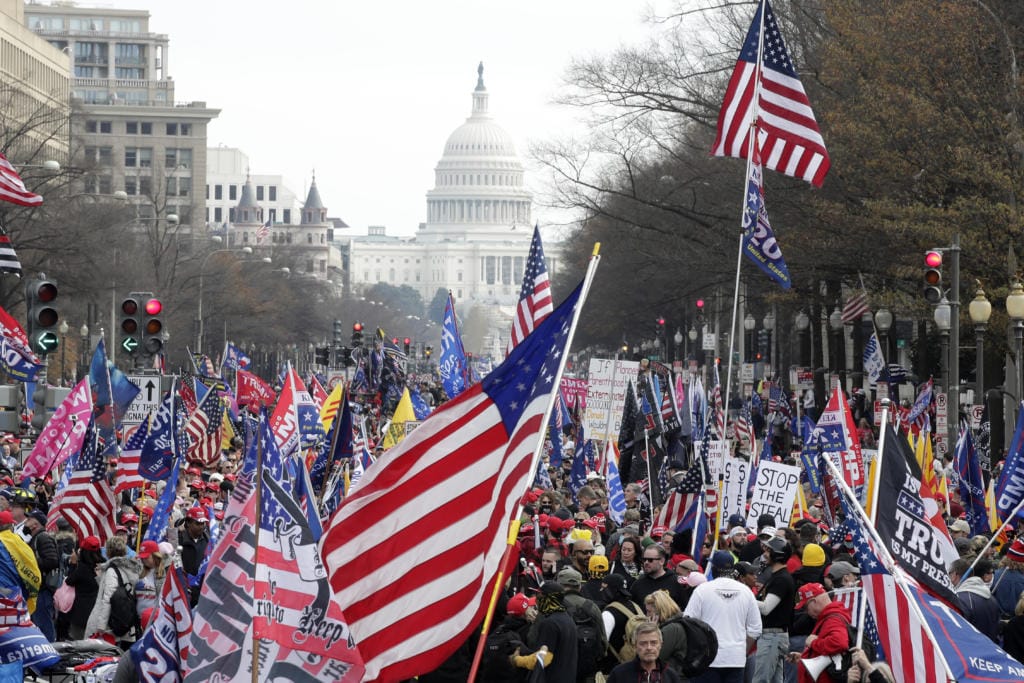 FILE - In this Saturday, Dec. 12, 2020, file photo, with the U.S. Capitol building in the background, supporters of President Donald Trump stand along Pennsylvania Avenue during a rally at Freedom Plaza, in Washington. Vandalism at four downtown Washington churches after rallies in support of Trump are exposing rifts among people of faith as the nation confronts bitter post-election political divisions. (AP Photo/Luis M.