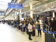 People at St Pancras station in London, wait to board the last train to Paris today, Sunday Dec. 20, 2020. Millions of people in England have learned they must cancel their Christmas get-togethers and holiday shopping trips. British Prime Minister Boris Johnson said Saturday that holiday gatherings can’t go ahead and non-essential shops must close in London and much of southern England.