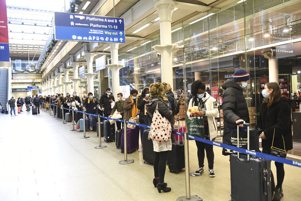 People at St Pancras station in London, wait to board the last train to Paris today, Sunday Dec. 20, 2020. Millions of people in England have learned they must cancel their Christmas get-togethers and holiday shopping trips. British Prime Minister Boris Johnson said Saturday that holiday gatherings can’t go ahead and non-essential shops must close in London and much of southern England.