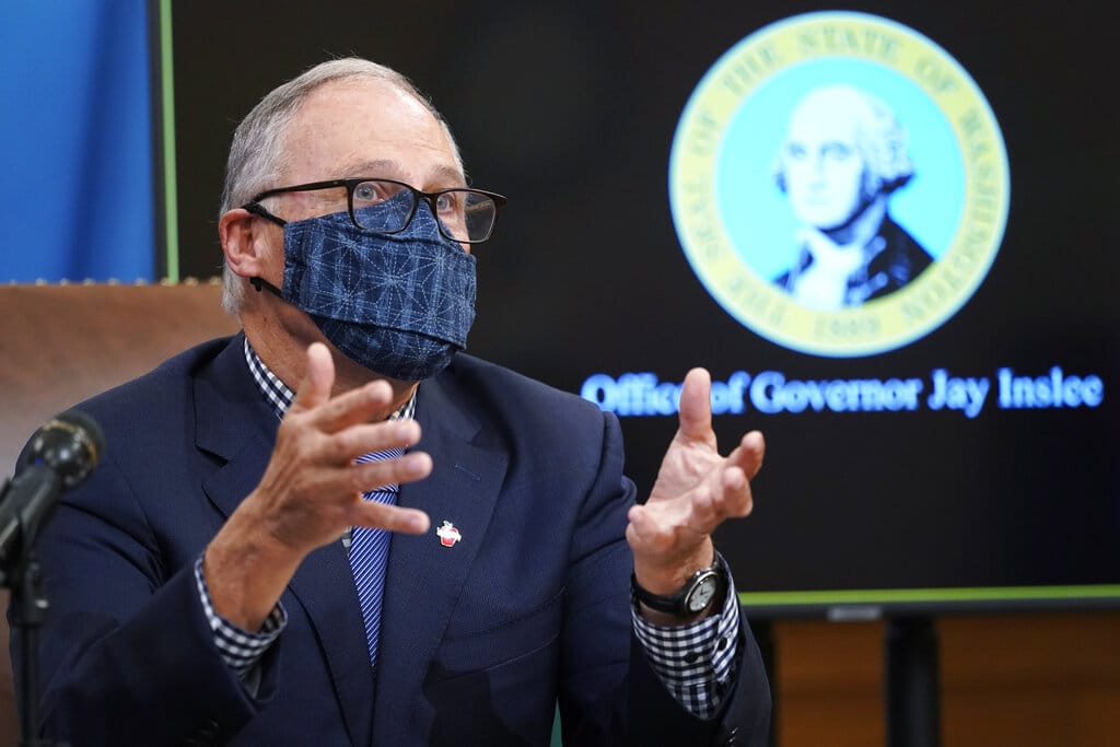 FILE - In this Dec. 17, 2020 file photo, Washington Gov. Jay Inslee talks to reporters at the Capitol in Olympia, Wash.  State lawmakers across the country will be convening in 2021 with the continuing COVID-19 pandemic rippling through much of their work — and even affecting the way they work. After 10 months of emergency orders and restrictions from governors and local executive officials, some state lawmakers are eager to reassert their power over statewide decisions shaping the way people shop, work, worship and attend school  (AP Photo/Ted S.