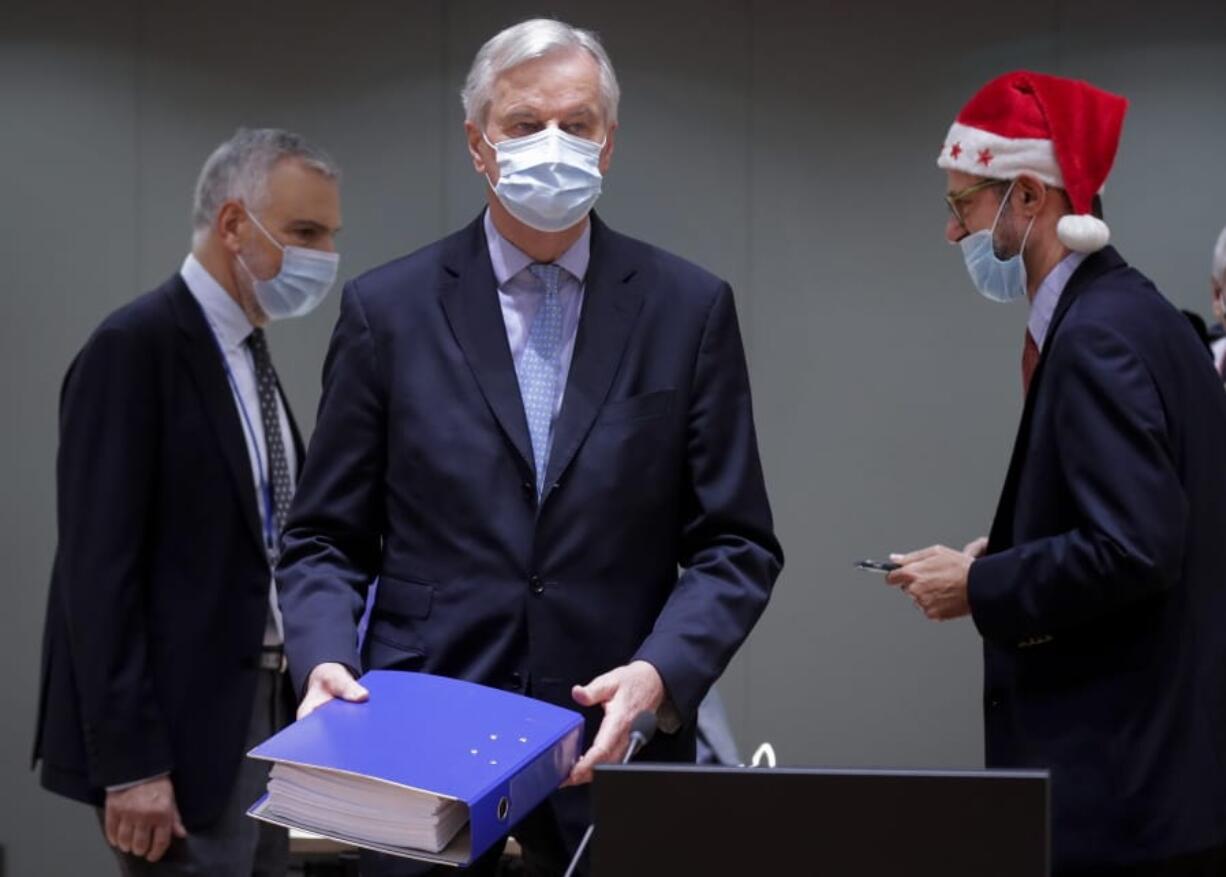 European Union chief negotiator Michel Barnier carries a binder of the Brexit trade deal Friday during a special meeting of Coreper, at the European Council building in Brussels.