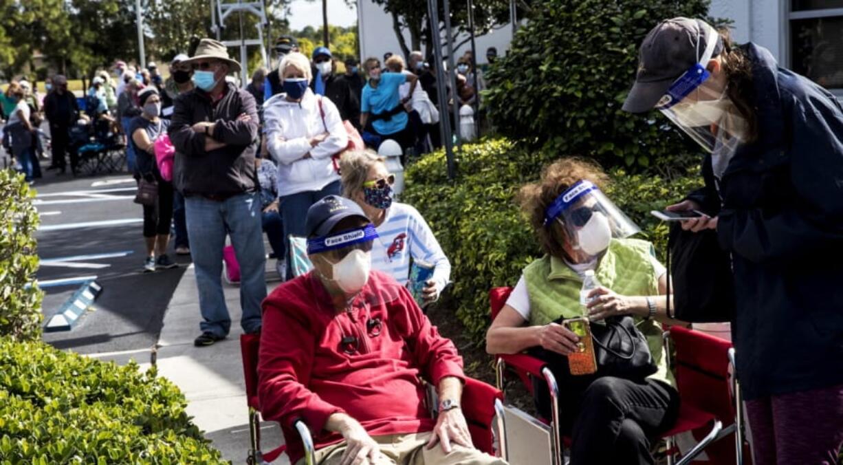 Joel and Susan Pittelman, from Naples, Fla., wait in line to receive COVID-19 vaccines on Tuesday, Dec. 29, 2020, at East County Regional Library in Lehigh Acres, Fla.