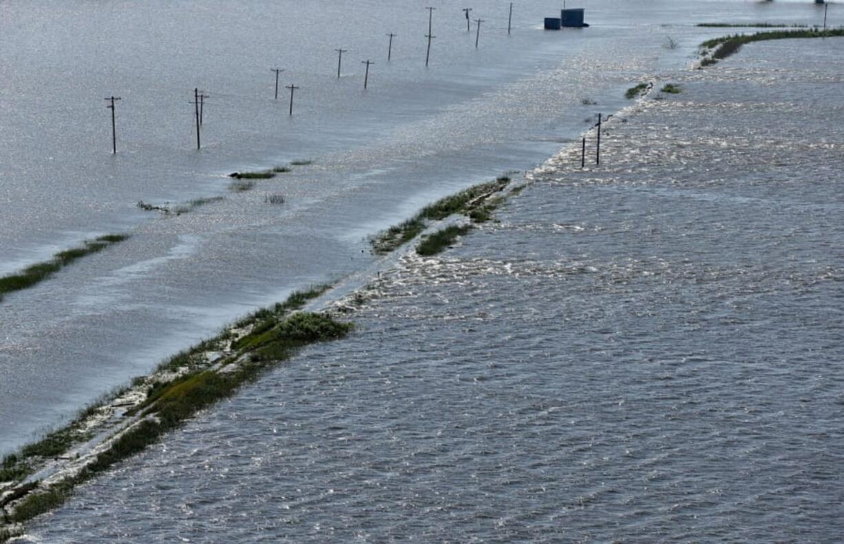 FILE - In this June 5, 2019, file photo, Mississippi River flows over the breached Pin Oak levee flooding homes and buildings in Winfield, Mo., during historic flooding on the river. The group America&#039;s Watershed Initiative on Tuesday, Dec. 8, 2020, released a report card giving the watershed a C- grade. The watershed includes the Mississippi River and tributaries that include the Missouri, Ohio and Tennessee rivers. The report cites concerns about water quality and frequent and extreme flooding along the rivers. (David Carson/St.