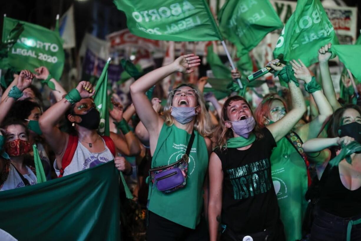 Abortion-rights activists watch live video streaming of lawmakers in session, outside Congress in Buenos Aires, Argentina, Wednesday, Dec. 30, 2020. Congress approved a bill that legalize abortion in Argentina.