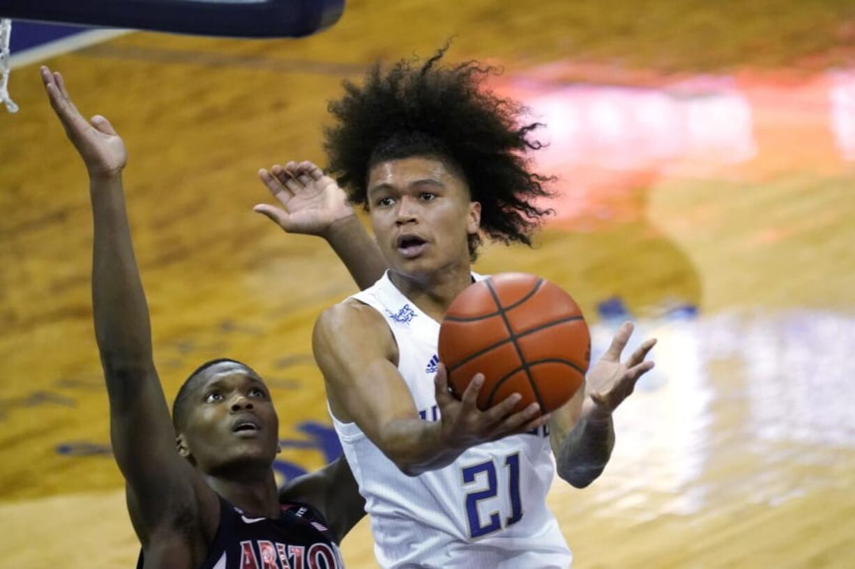 Washington&#039;s RaeQuan Battle (21) shoots over Arizona&#039;s Bennedict Mathurin during the first half of an NCAA college basketball game Thursday, Dec. 31, 2020, in Seattle.