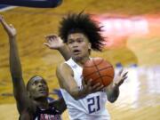 Washington&#039;s RaeQuan Battle (21) shoots over Arizona&#039;s Bennedict Mathurin during the first half of an NCAA college basketball game Thursday, Dec. 31, 2020, in Seattle.