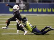 Seattle Seahawks strong safety Jamal Adams, right, gets to Arizona Cardinals quarterback Kyler Murray (1) just as Murray gets a pass off, during the second half of an NFL football game, Thursday, Nov. 19, 2020, in Seattle.