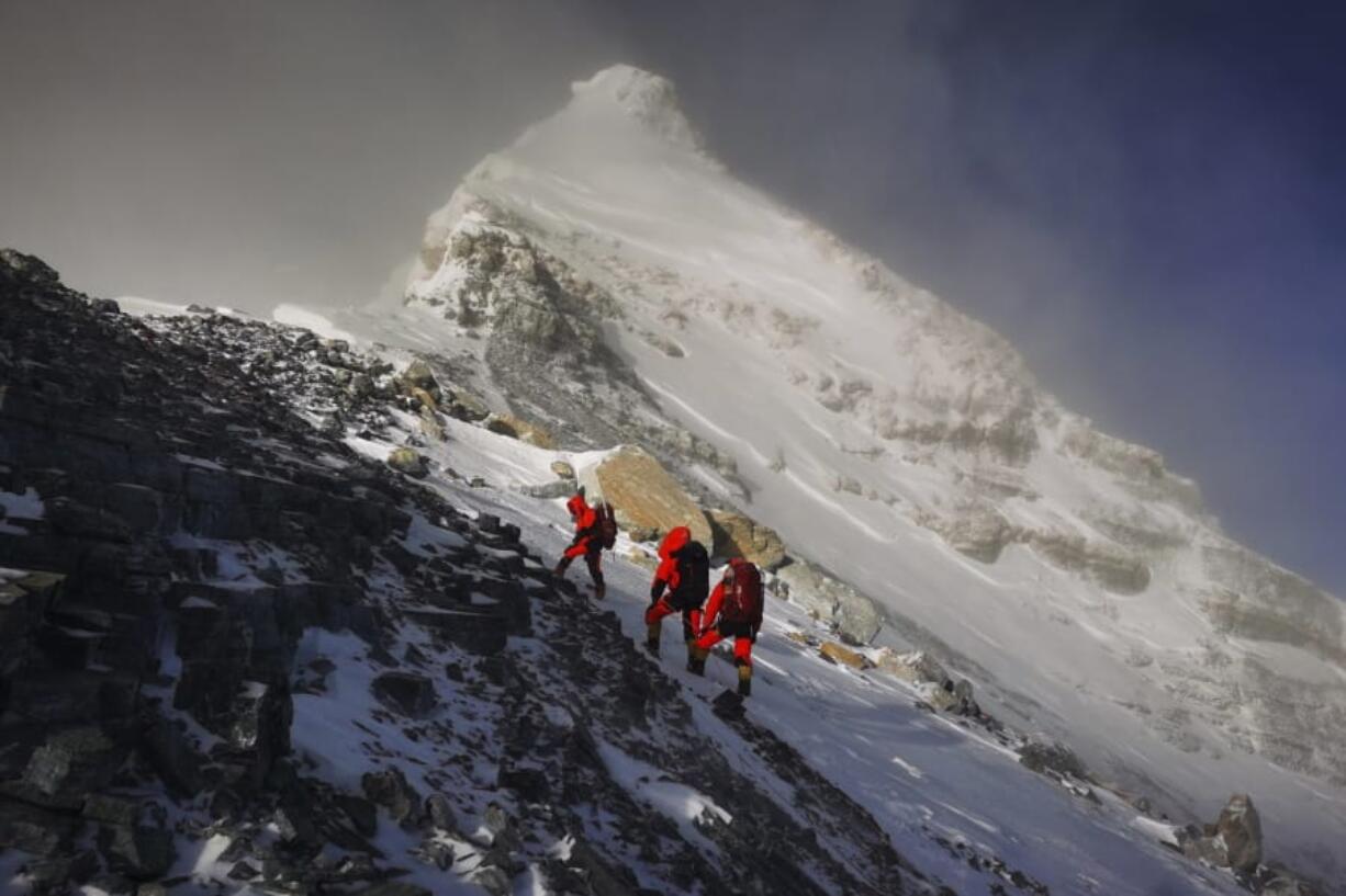 FILE - In this May 27, 2020, file photo released by Xinhua News Agency, members of a Chinese surveying team head for the summit of Mount Everest, also known locally as Mt. Qomolangma. China and Nepal have jointly announced on Tuesday, Dec. 8, 2020, a new height for Mount Everest, ending a discrepancy between the two nations.