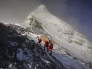 FILE - In this May 27, 2020, file photo released by Xinhua News Agency, members of a Chinese surveying team head for the summit of Mount Everest, also known locally as Mt. Qomolangma. China and Nepal have jointly announced on Tuesday, Dec. 8, 2020, a new height for Mount Everest, ending a discrepancy between the two nations.