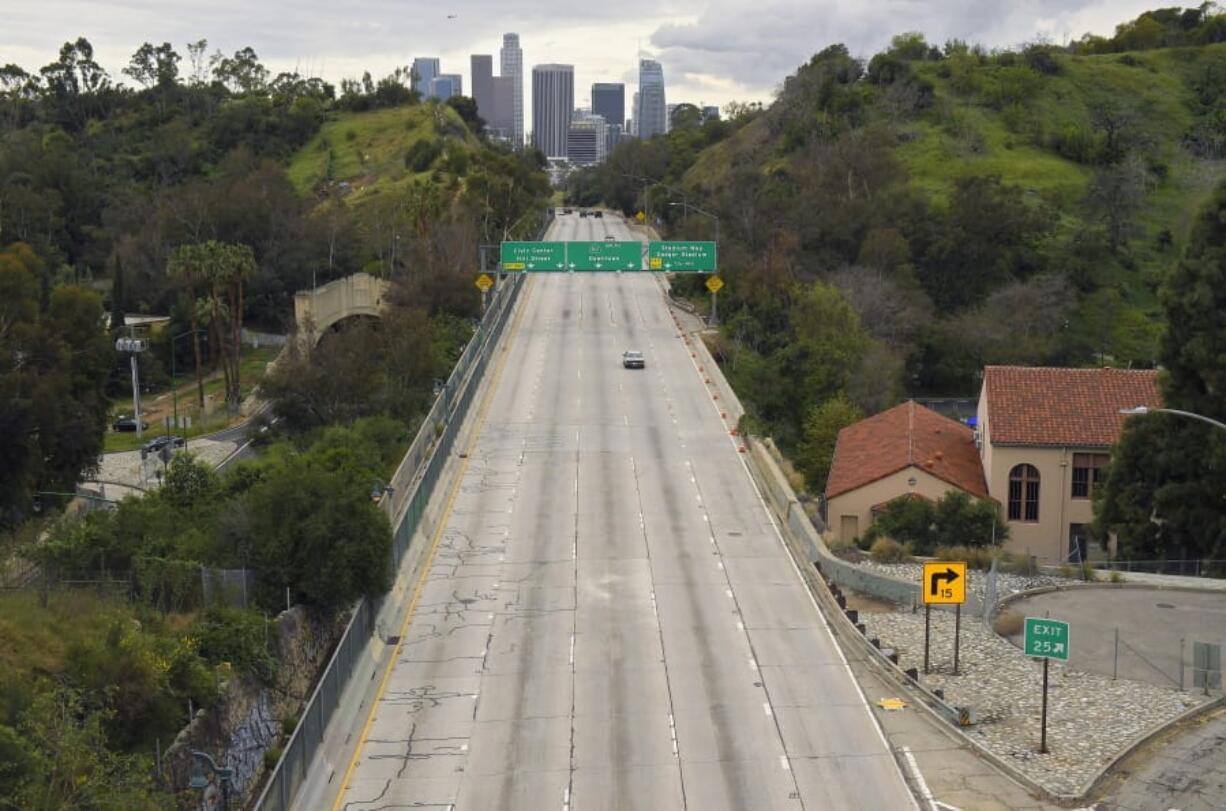 FILE - In this Friday, March 20, 2020 file photo, extremely light traffic moves along the 110 Harbor Freeway toward downtown Los Angeles in the mid-afternoon. Traffic would normally be bumper-to-bumper during this time of day on a Friday. New calculations released on Thursday, Dec. 10, 2020, show the world&#039;s carbon dioxide emissions plunged 7% in 2020 because of the pandemic lockdowns. (AP Photo/Mark J.