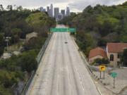 FILE - In this Friday, March 20, 2020 file photo, extremely light traffic moves along the 110 Harbor Freeway toward downtown Los Angeles in the mid-afternoon. Traffic would normally be bumper-to-bumper during this time of day on a Friday. New calculations released on Thursday, Dec. 10, 2020, show the world&#039;s carbon dioxide emissions plunged 7% in 2020 because of the pandemic lockdowns. (AP Photo/Mark J.