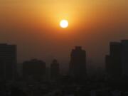 FILE - In this Thursday, Feb. 20, 2020 file photo, the sun rises amid smog during the dry season in Mexico City. Five years after a historic climate deal in Paris, world leaders are again meeting to increase their efforts to fight global warming.