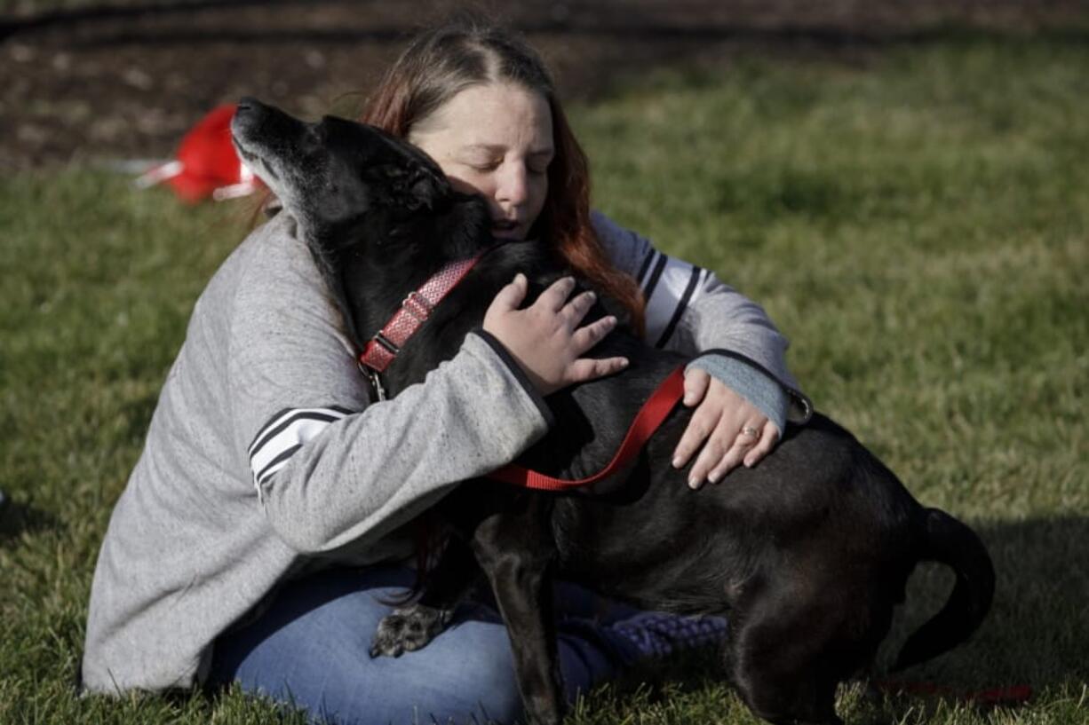 Debra Mejeur hugs her dog Lola on Dec. 5 outside DuPage County Animal Services, in Wheaton, Ill., as they reunite three years after Lola went missing during a trip to suburban Chicago.