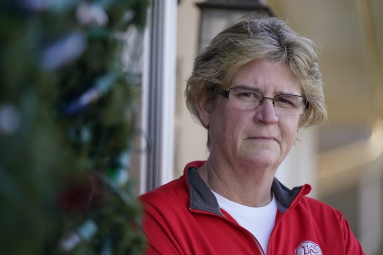 Keli Paaske stands outside her home in Olathe, Kan. Friday, Dec. 4, 2020. Paaske was laid off in August from a company supplying fire doors to hospitals after being furloughed for five months and has struggled to find a new job.