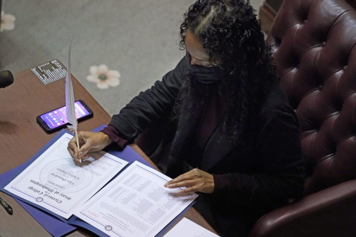 Democrat Sophia Danenberg, a member of Washington&#039;s Electoral College, fills in her ballot for Vice President-elect Kamala Harris at the state Capitol in Olympia, Wash., Monday, Dec. 14, 2020. (AP Photo/Ted S.