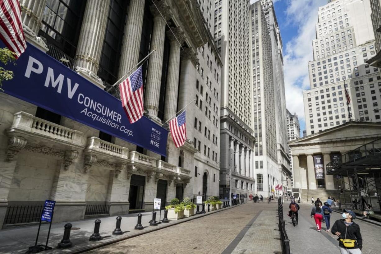 FILE - Pedestrians pass the New York Stock Exchange, Friday, Oct. 2, 2020, in New York.    Stocks are ticking higher on Wall Street Wednesday, Dec. 23,  following a mixed set of reports on the economy.