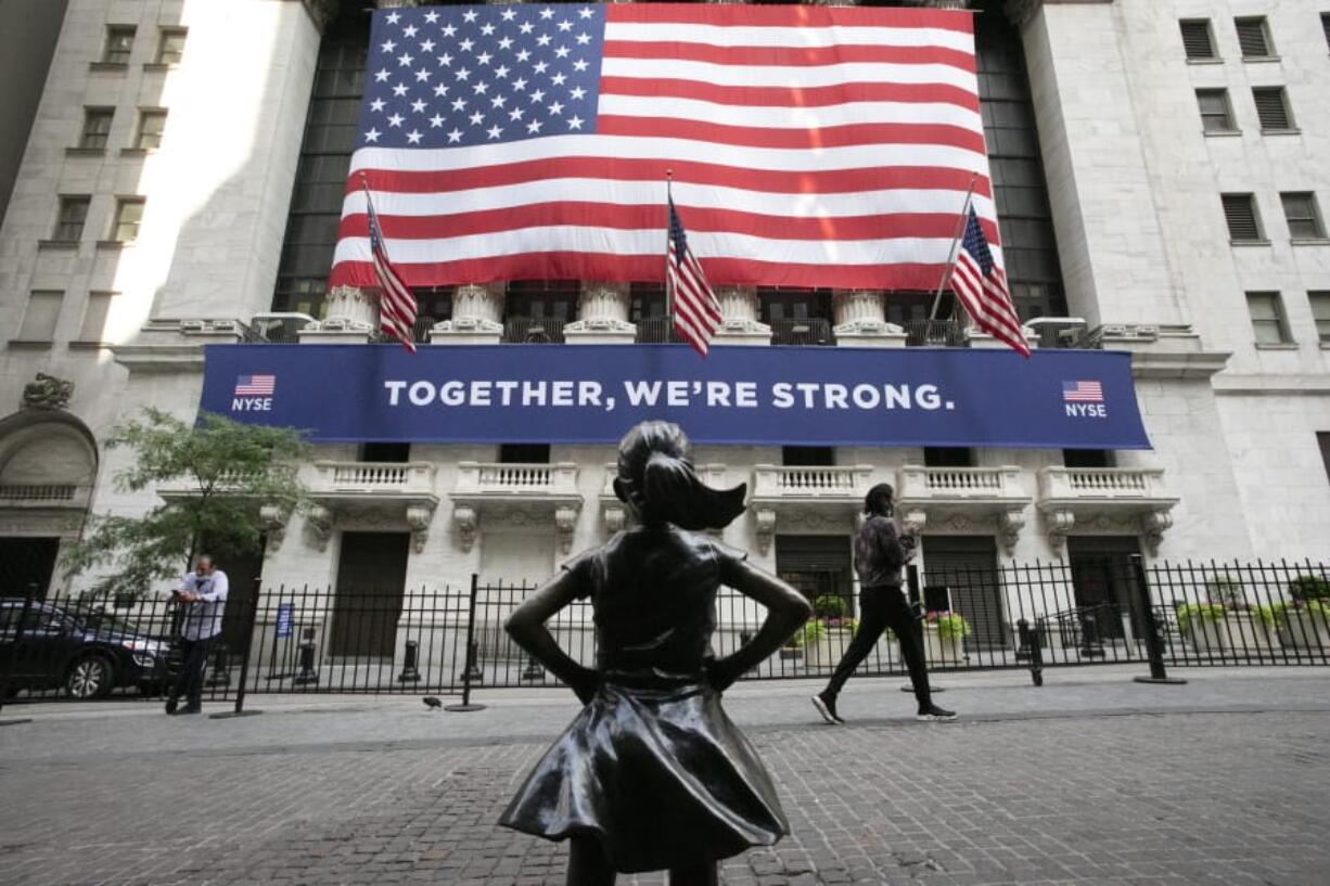 FILE - In this July 9, 2020 file photo, the Fearless Girl statue stands in front of the New York Stock Exchange in New York. Stocks are off to a mixed start, Thursday, Dec. 31,  on Wall Street on the last day of 2020, a year that saw a breathtaking nosedive in markets in the spring as the coronavirus took hold followed by steady gains in the months that followed as hopes built for an eventual return to something like normal.