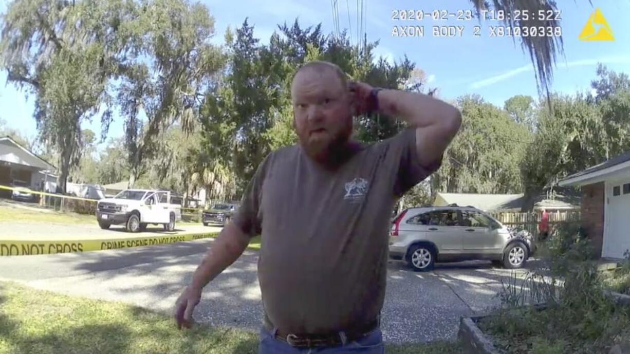 In this Feb. 23, 2020 image taken from Glynn, Ga., County Police body camera video, Travis McMichael speaks to a police officer at the scene where Ahmaud Arbery, a 25-year-old Black man, was shot and killed while while running in a neighborhood outside the port city of Brunswick, Ga. Father and son Gregory and Travis McMichael were arrested on murder charges in May, more than two months after the incident. A third man, William &quot;Roddie&quot; Bryan Jr., who shot cellphone video of the incident was charged with murder for joining the chase.