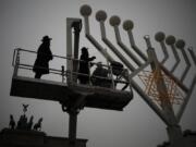 Rabbi Yehuda Teichtal, left, and Rabbi Segal Shmoel, second from left, inspect a giant Hanukkah Menorah, set up by the Jewish Chabad Educational Center on Thursday ahead of the Jewish Hanukkah holiday, at the Pariser Platz in Berlin, Germany.